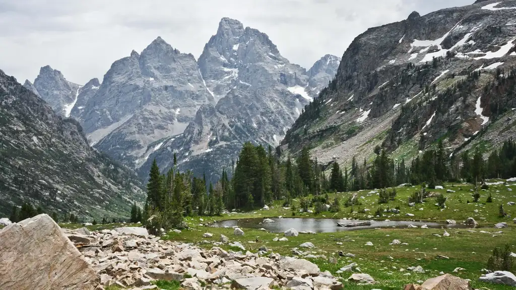 Grand Teton peaks above an alpine meadow and pond near Jackson Hole, Wyoming