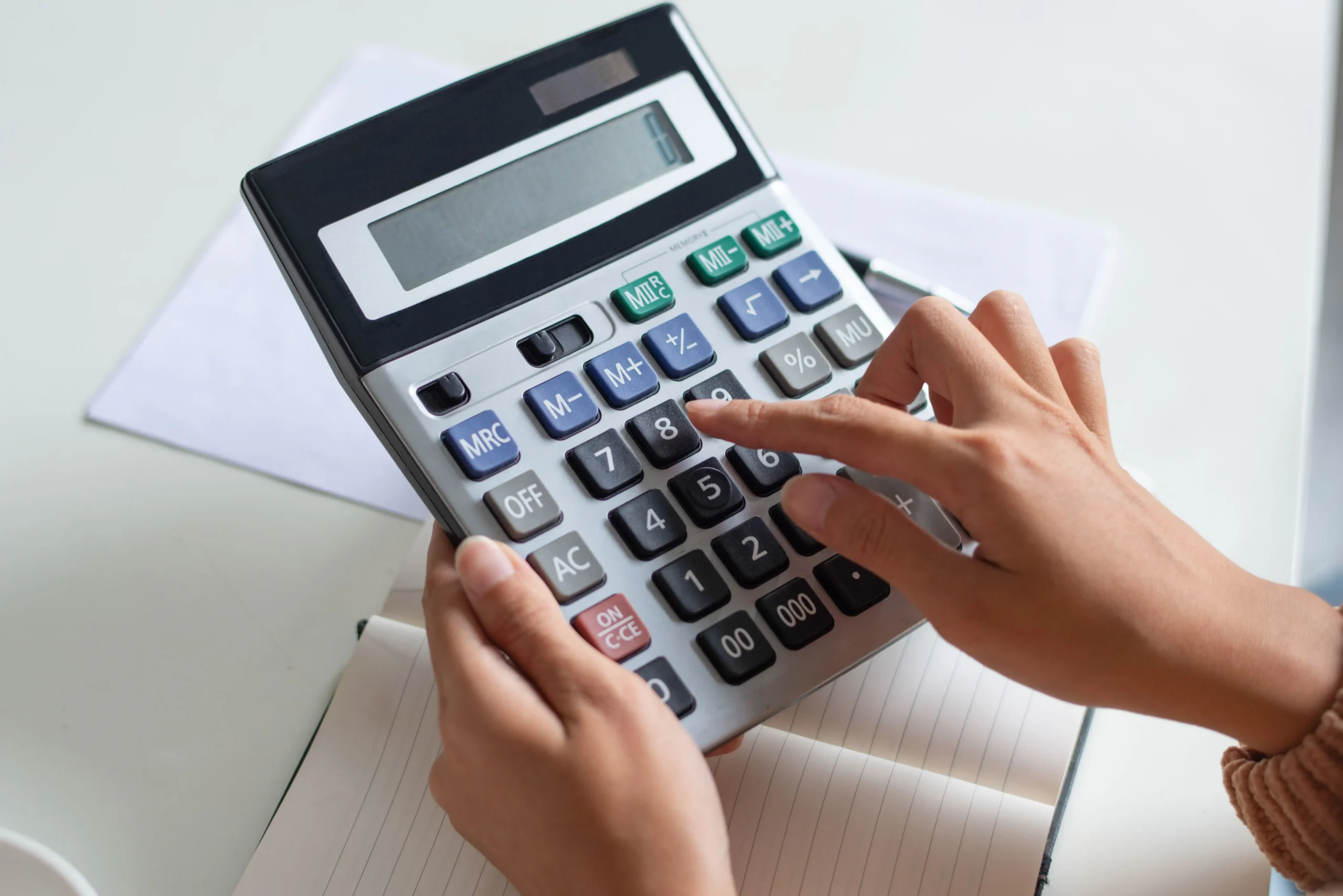 close-up-accountant-using-calculator-while-examining-report